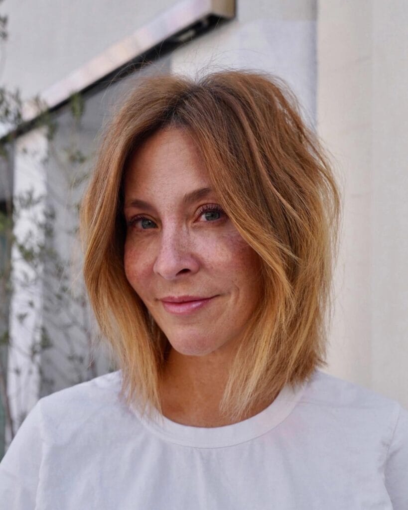 Shoulder length auburn shaggy bob with soft layers and lightly tousled texture around the face.