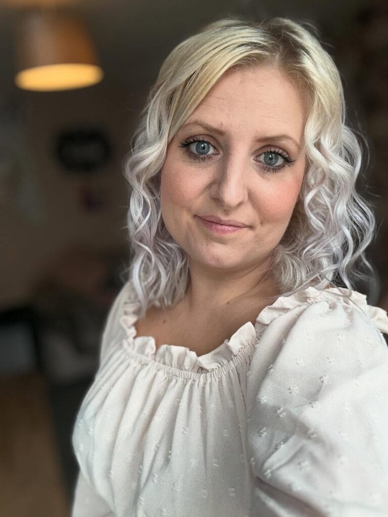 Medium length platinum blonde hair with soft wavy layers.