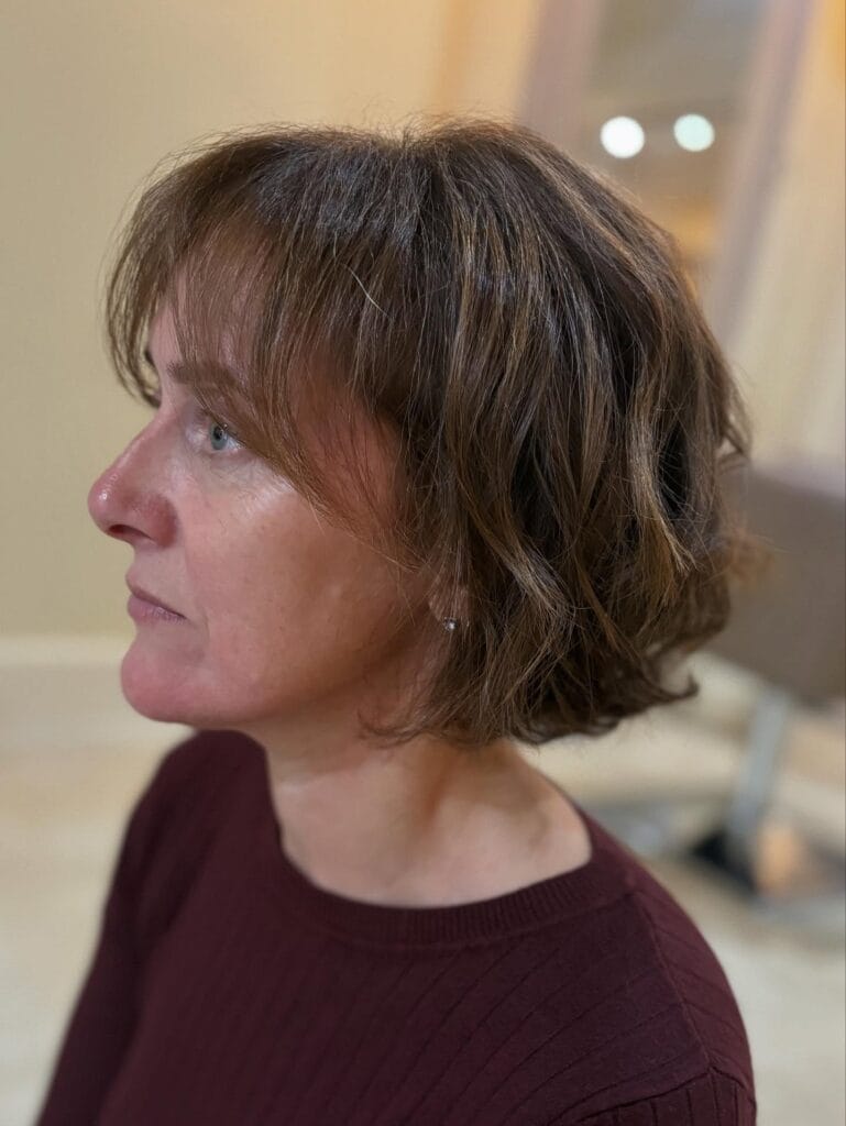 Short brunette bob with soft natural waves and light layering.