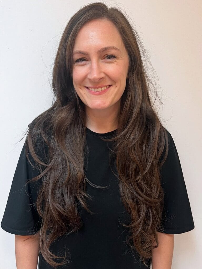 Long brown hair with soft flowing waves and subtle layers.