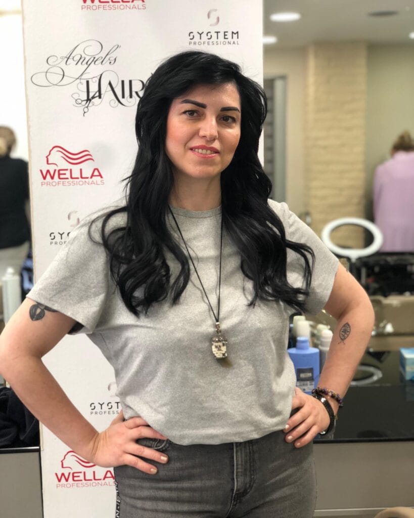 Long dark layered hair styled with glossy loose waves.