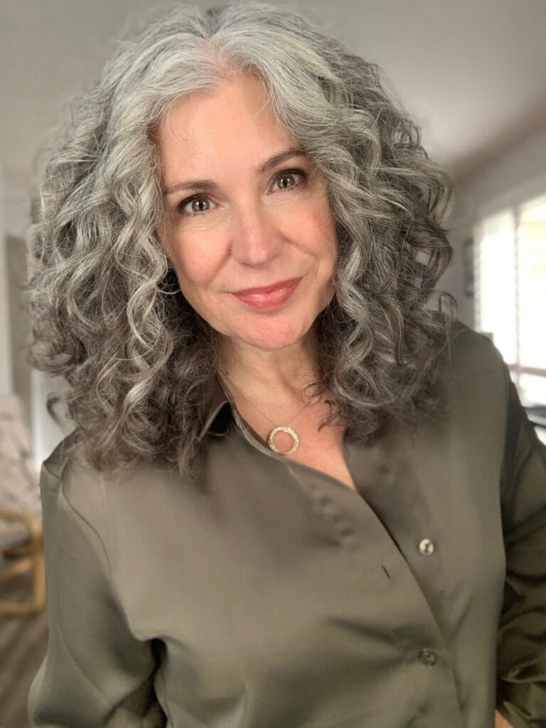 Medium length silver gray wavy hair with soft voluminous curls.
