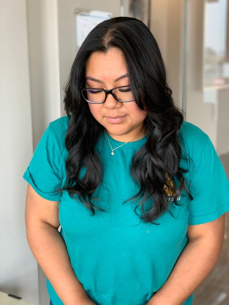 Long dark layered hair with soft loose waves and a natural finish.