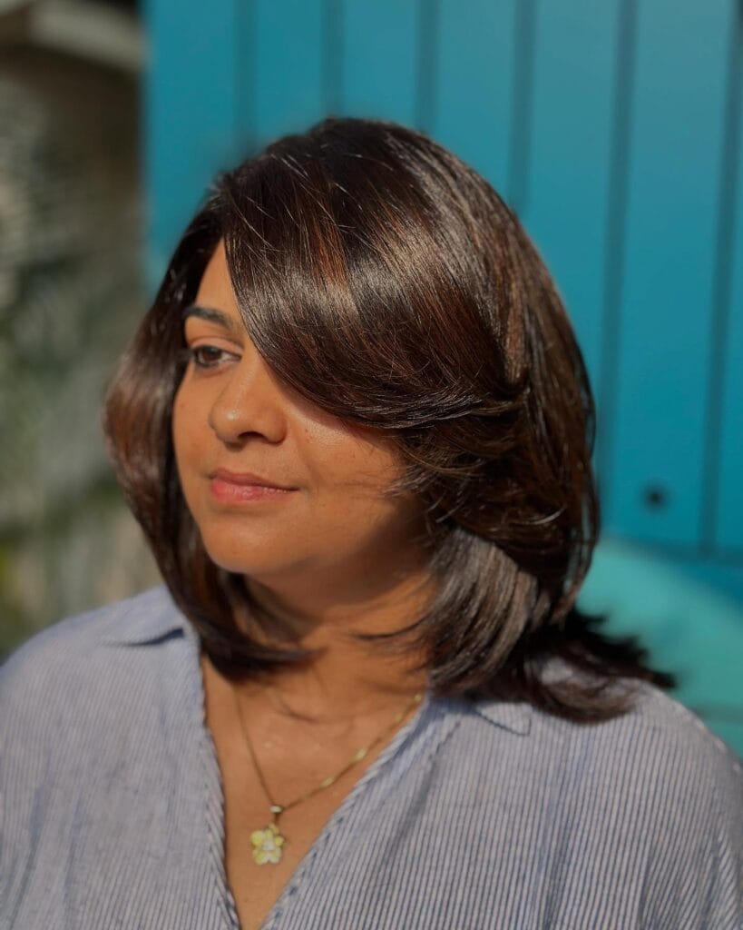 Medium length brown layered hair with long side bangs and a smooth, glossy finish.