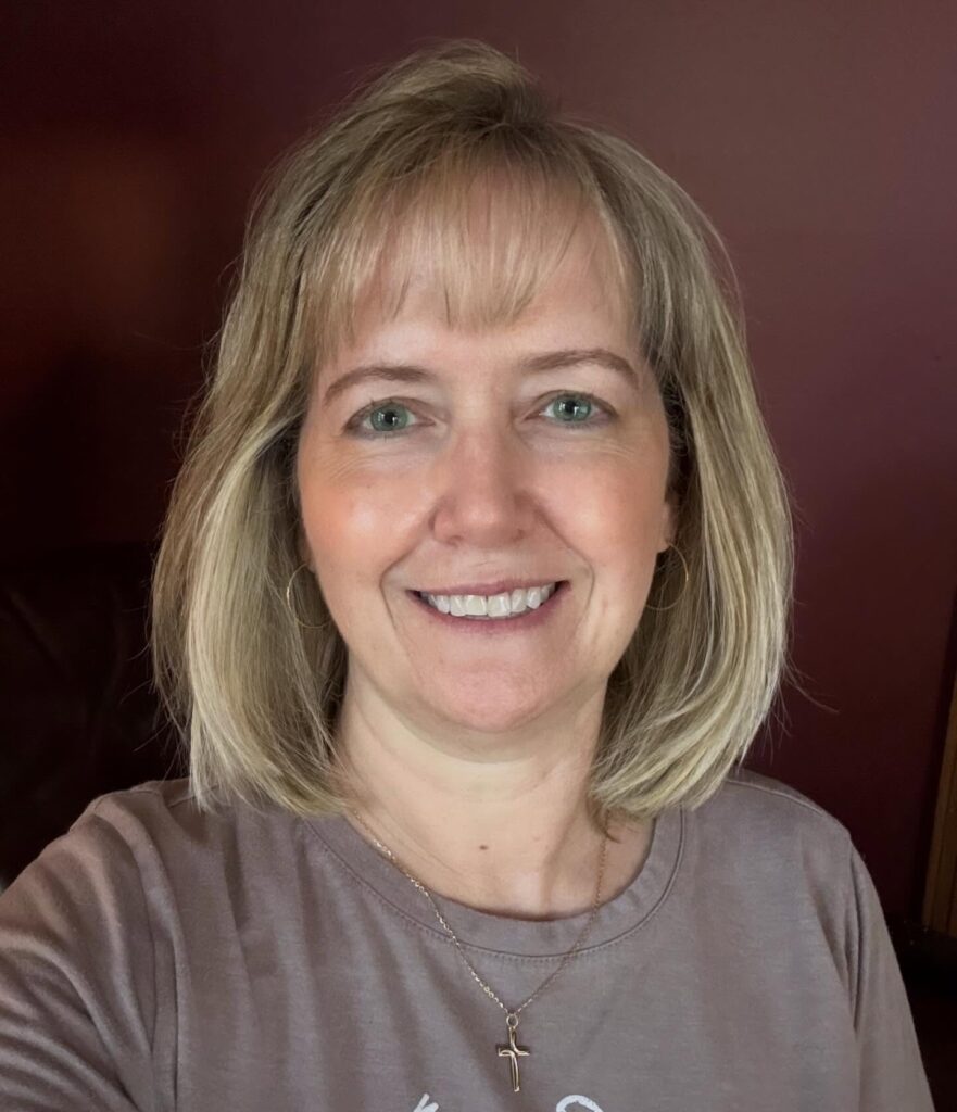 A woman with a shoulder-length golden blonde lob and thin, wispy bangs.