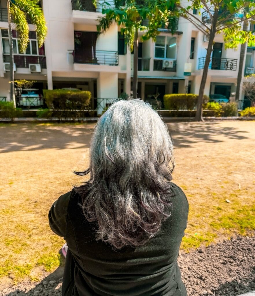 Long gray hair styled into soft voluminous curls.