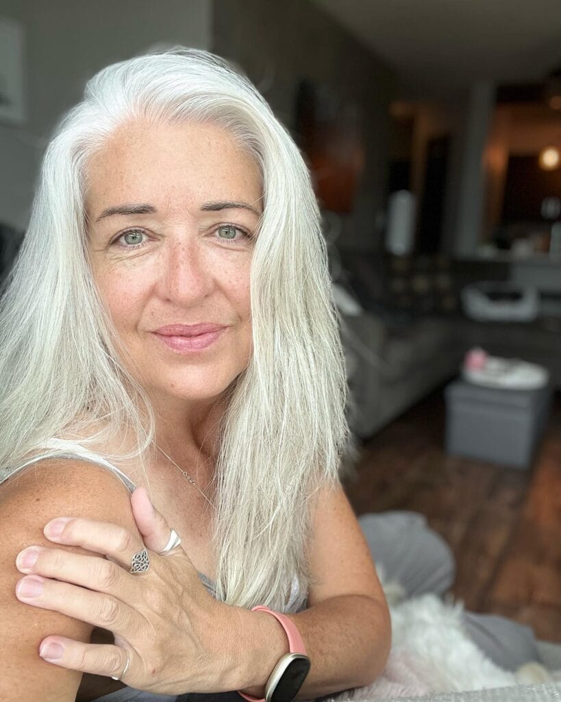 Long silver gray hair with soft face framing layers.