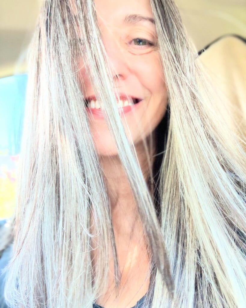 Long gray hair with soft volume at the crown and light waves.