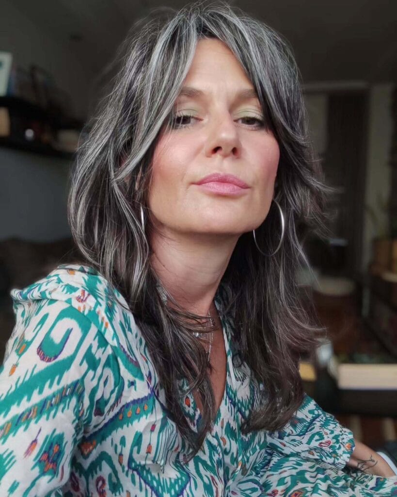 Long silver hair with soft face framing layers.