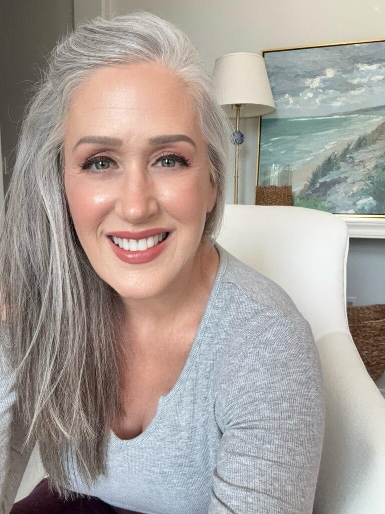 Long gray hair styled with loose waves and natural volume.