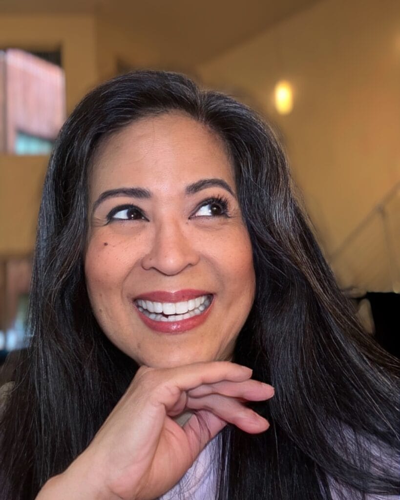 A woman with long dark brown layered hair styled sleek and smooth.