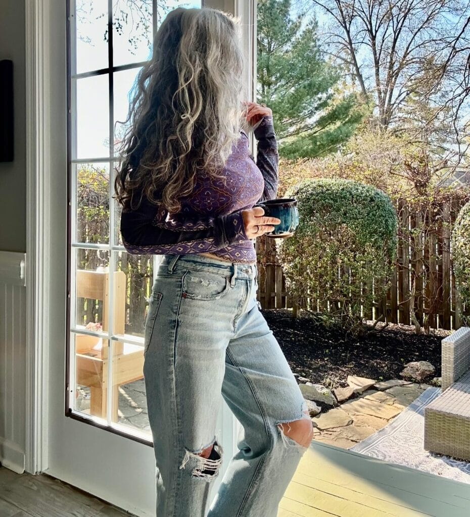 A woman with long natural gray hair styled in flowing layers.