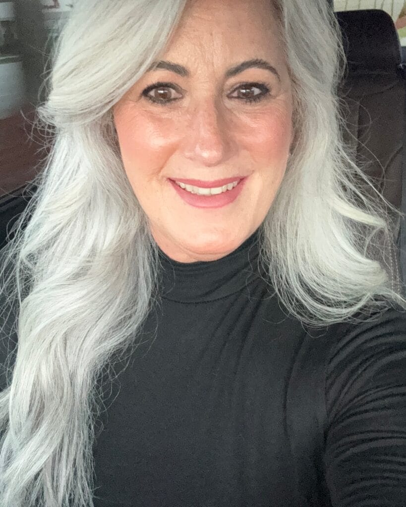 Long layered silver hairstyle with soft volume and flowing movement.