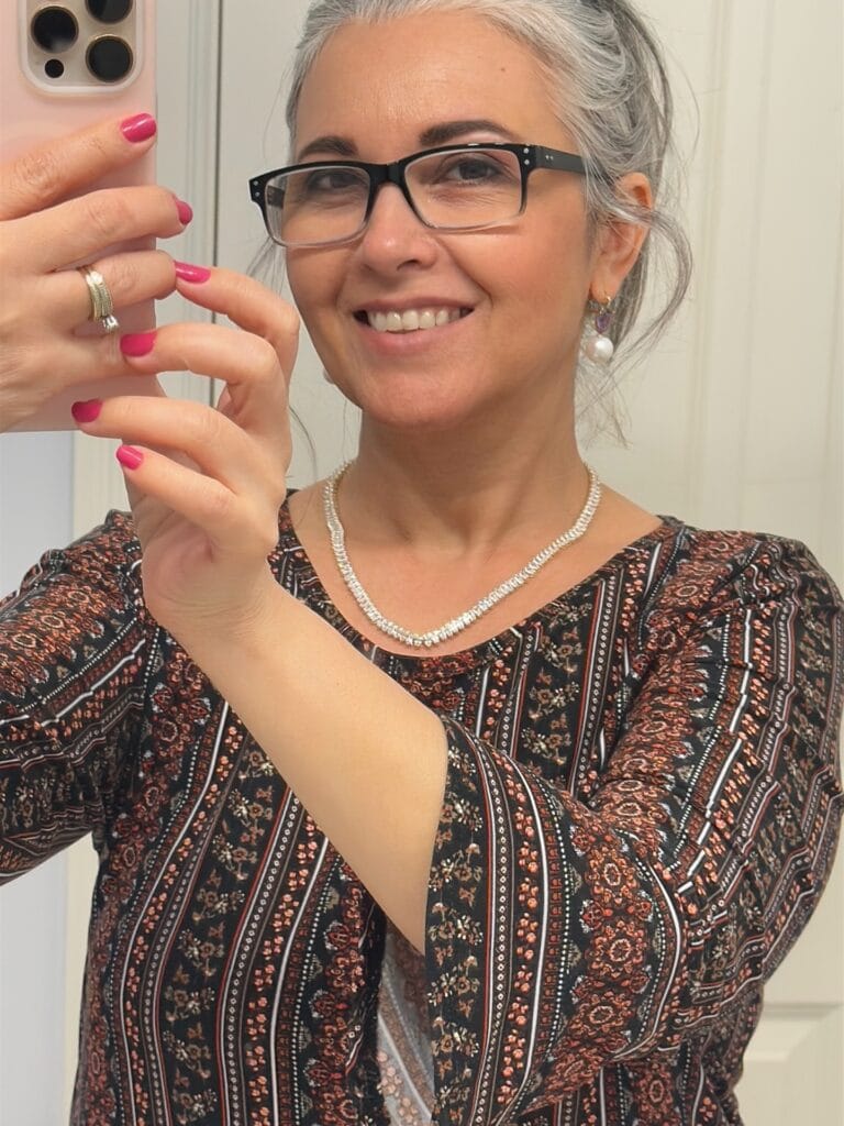 Gray hair styled into a relaxed textured updo with soft volume and loose face framing strands.