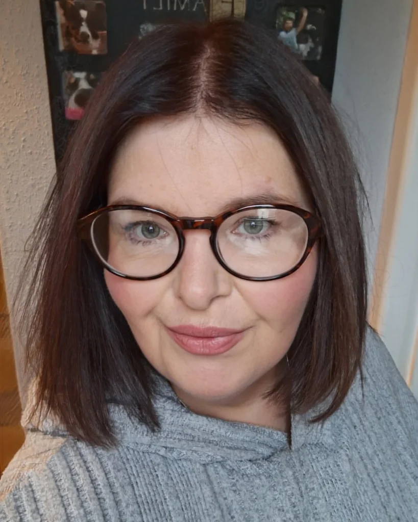 Straight shoulder length brunette bob with a center part and smooth texture.