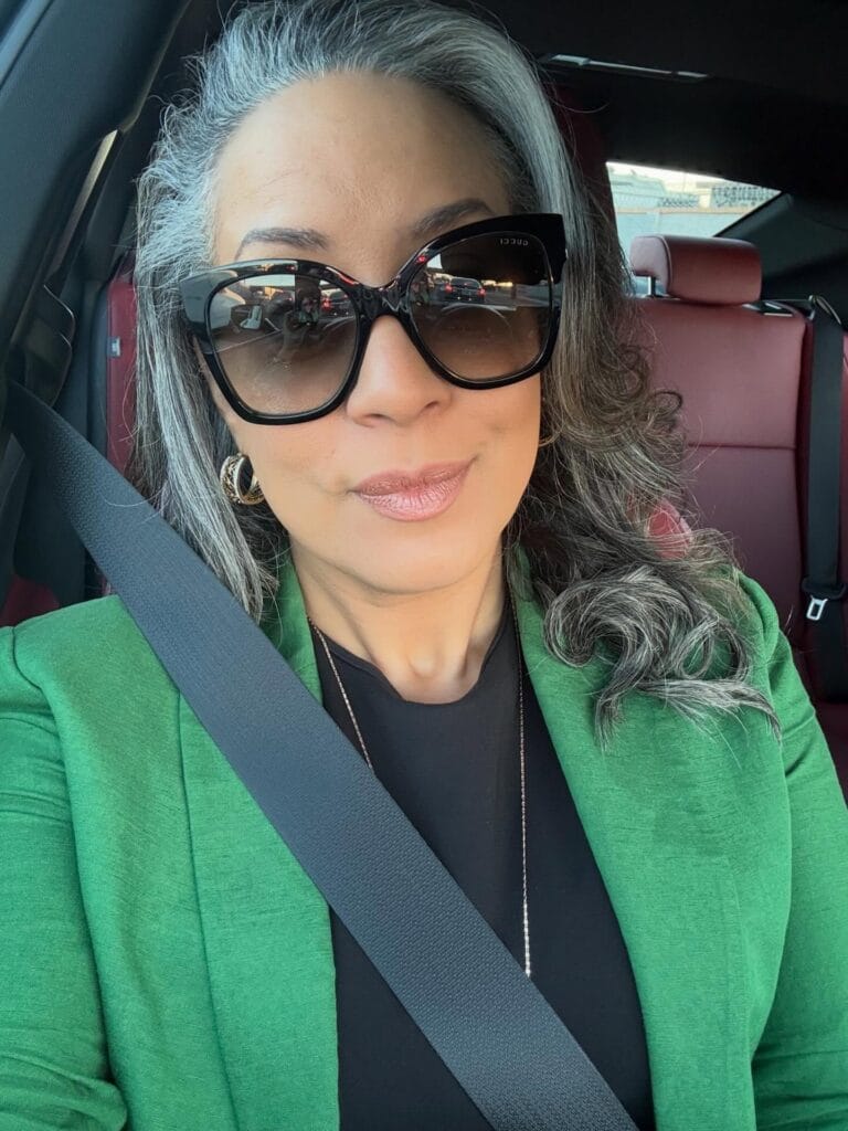 Medium length silver wavy hairstyle with a deep side part and soft volume.