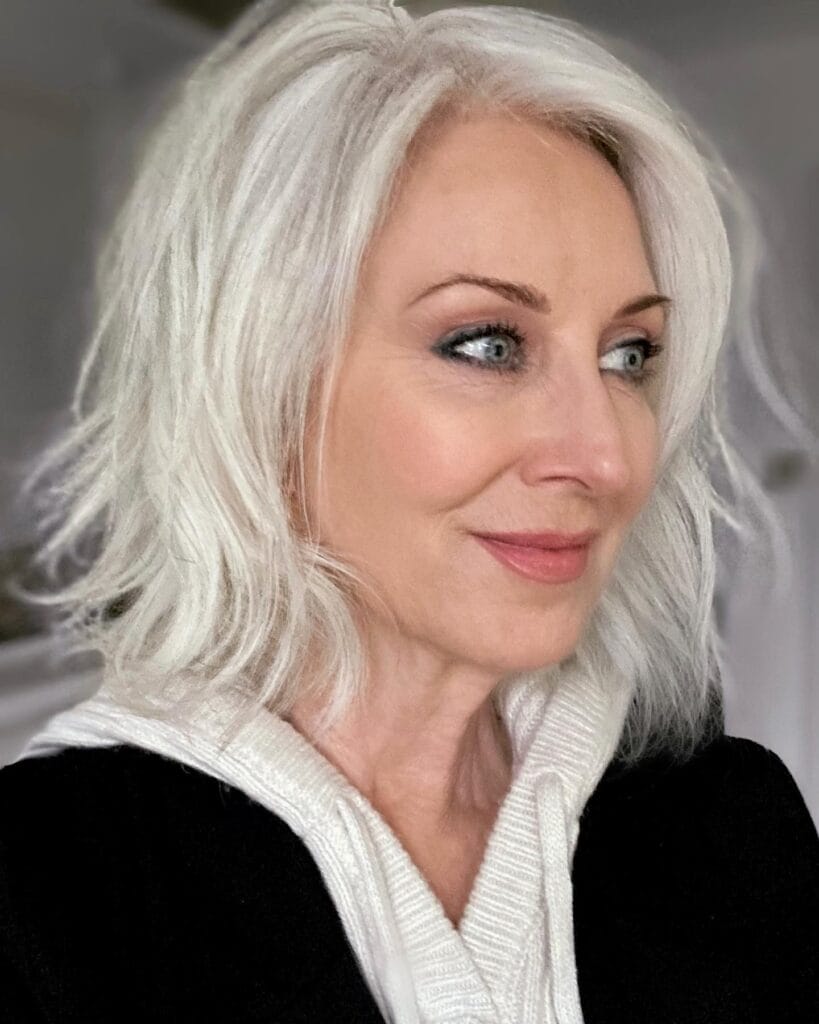 Shoulder length white gray bob with soft layers and feathery ends.