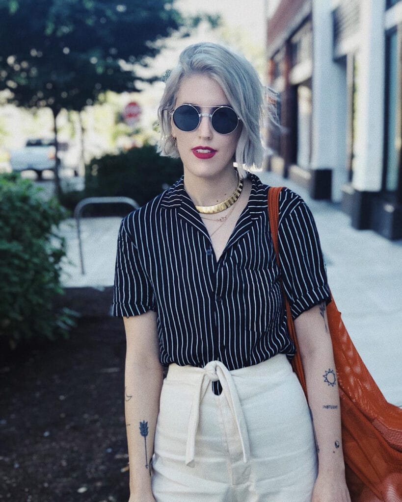 Short choppy gray bob with relaxed texture styled with sunglasses and casual outfit.