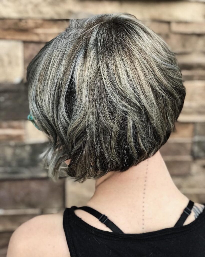 Layered gray bob with dark lowlights and textured back creating a full dimensional look.
