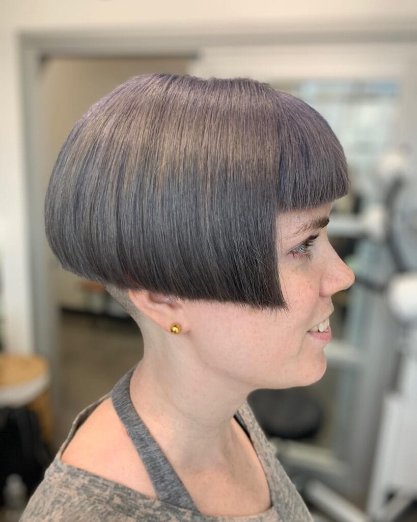 Rounded gray bowl cut bob with blunt fringe and smooth sculpted shape.