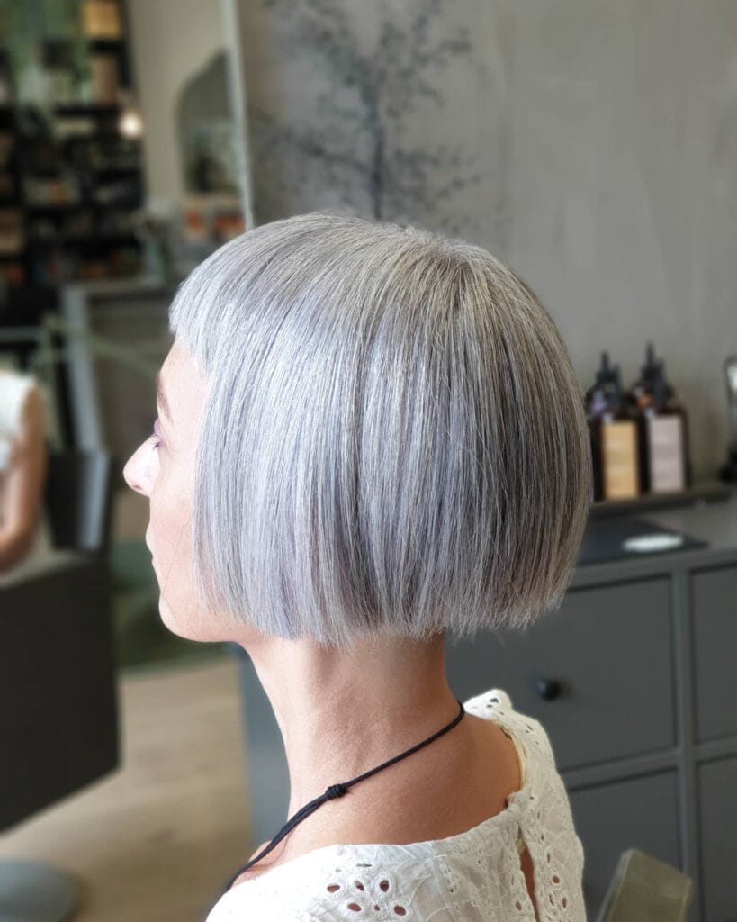Chin length blunt gray bob with straight ends and clean structured shape.