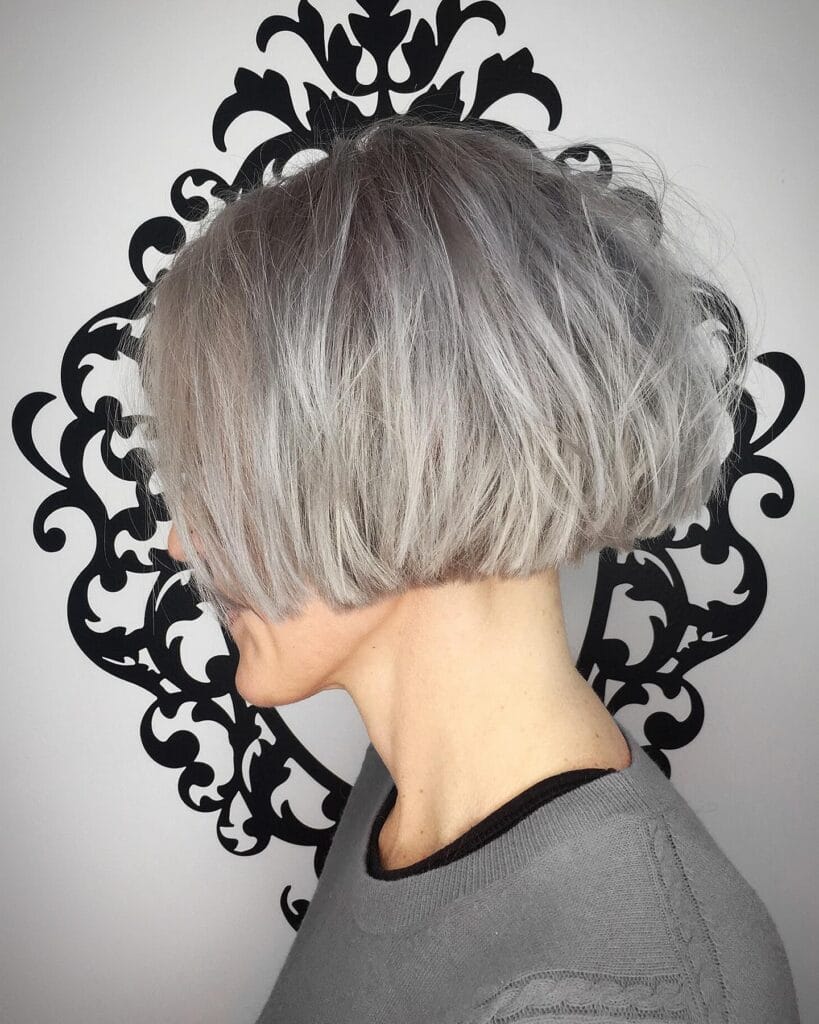 Rounded silver gray bob with tapered nape and smooth curved shape at the back.