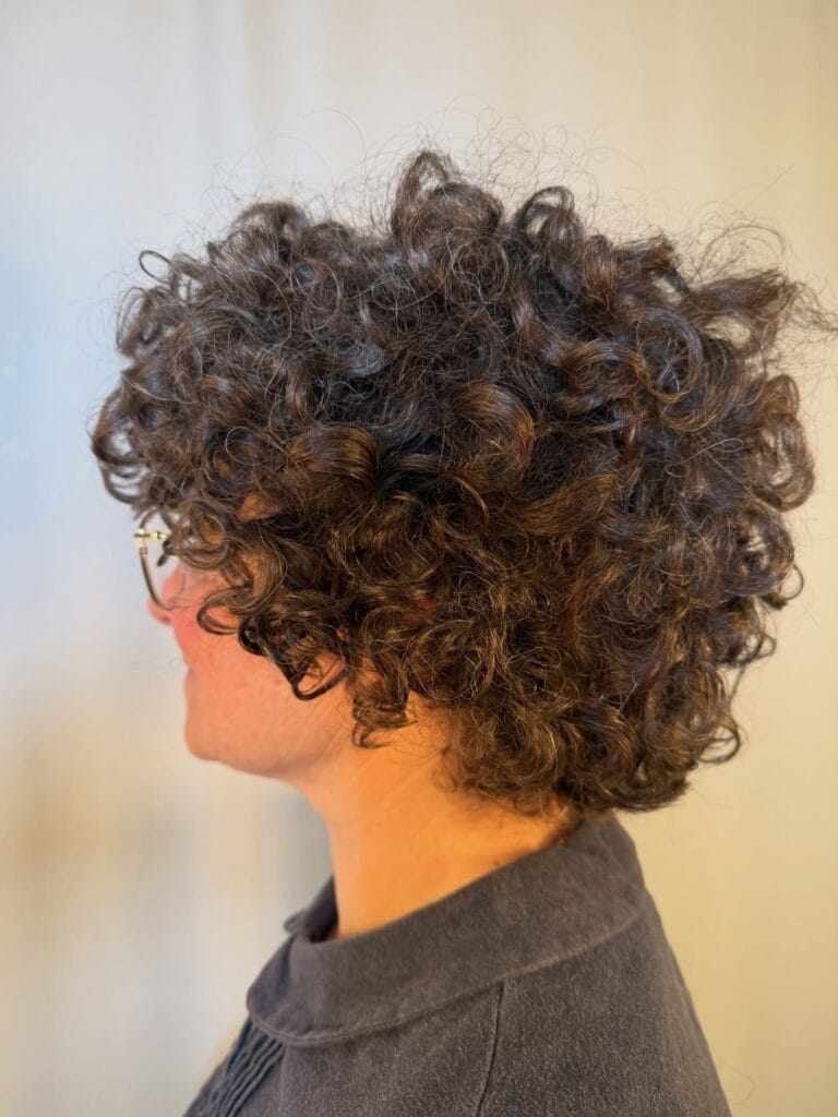 Short curly bob with tight defined curls and a rounded voluminous shape.