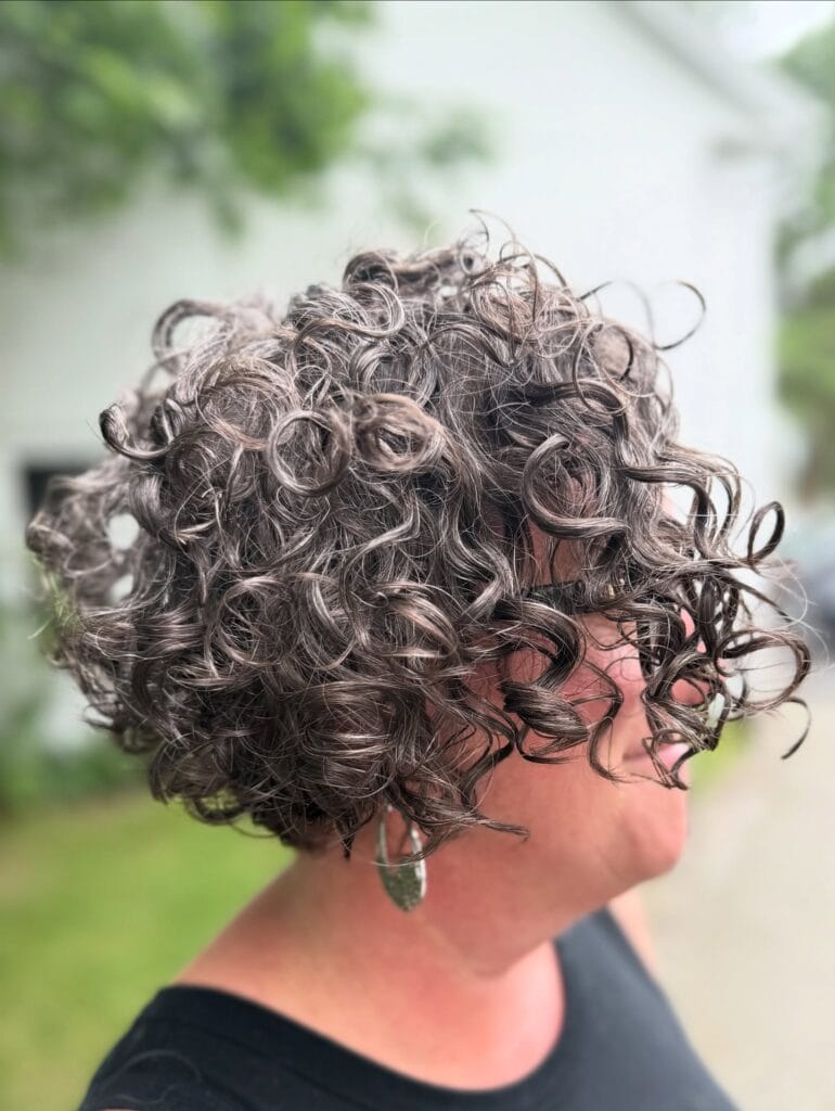 Voluminous curly bob with loose ringlets and soft layered shape.
