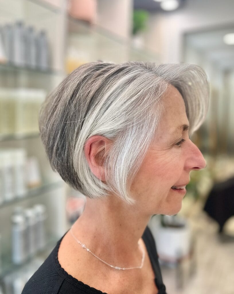 Short silver wavy bob with tapered back and soft waves on top.