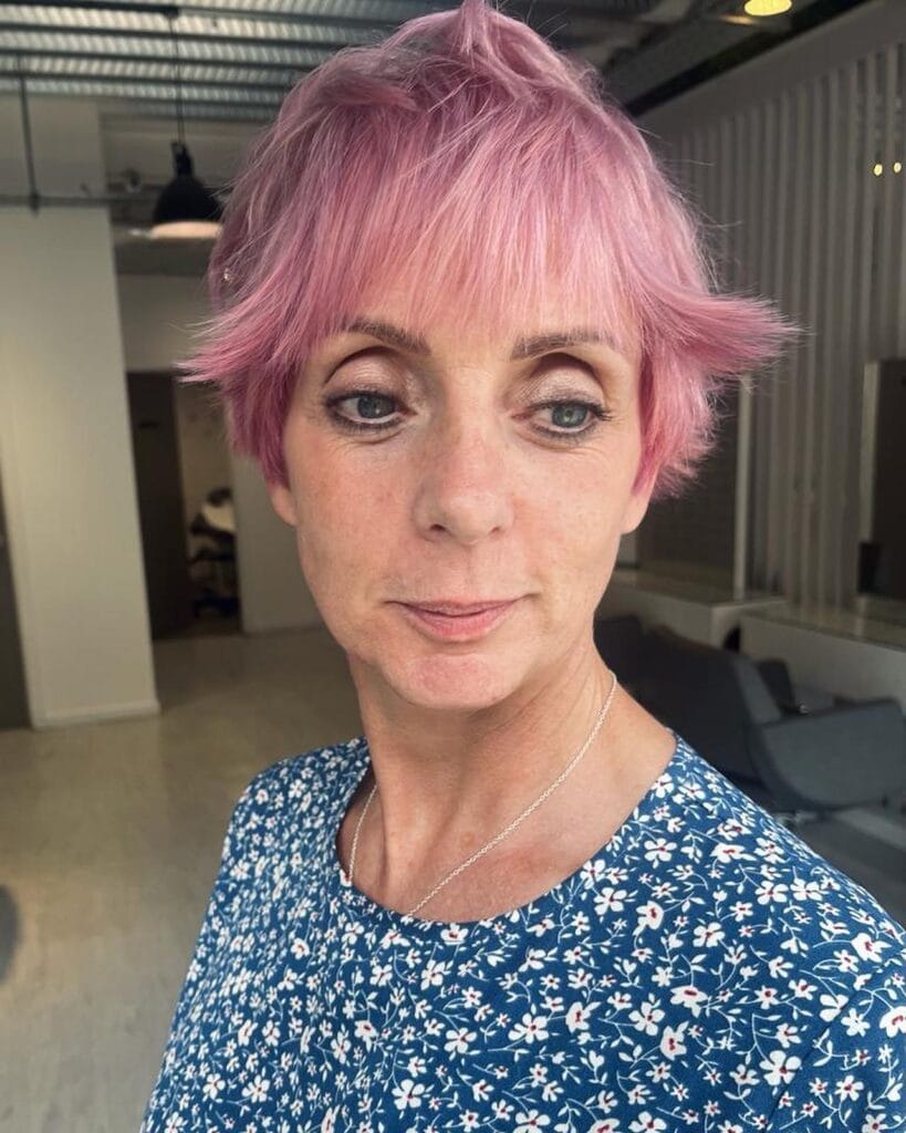 Short pink textured wavy crop with choppy layers and soft movement.