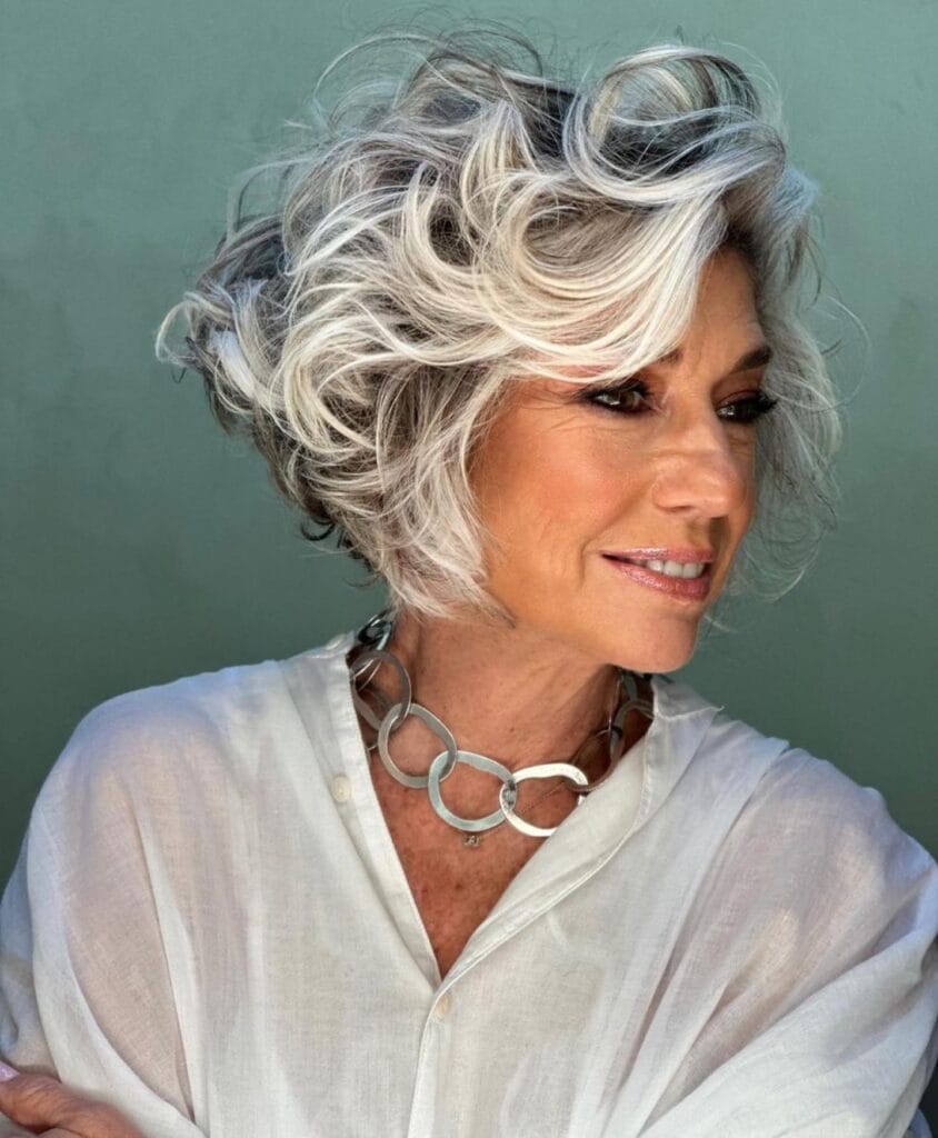 Short wavy bob with silver highlights and voluminous layered texture.