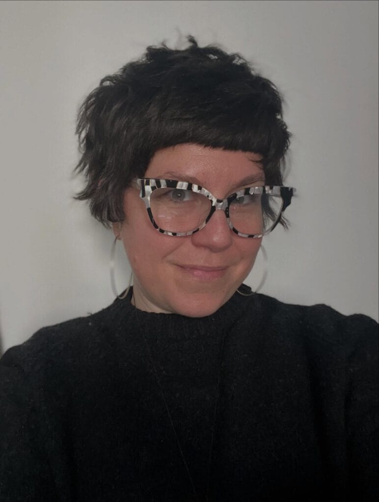 Short dark choppy pixie haircut with soft wavy layered texture.