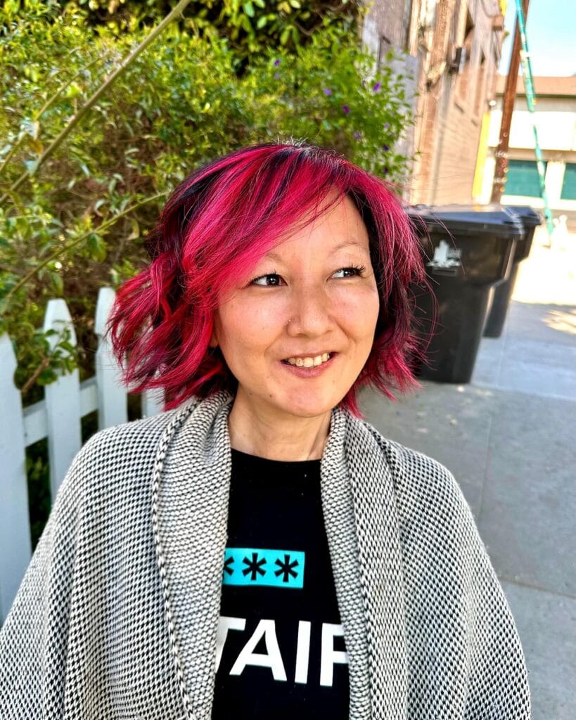 Short wavy bob with red highlights and layered textured waves.