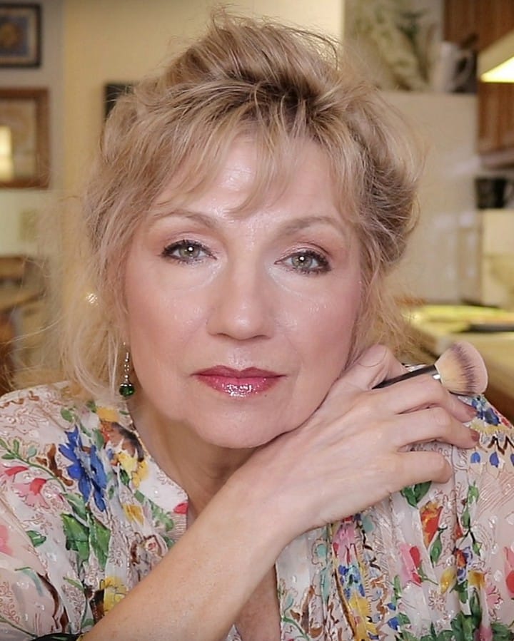 Short blonde wavy layered hairstyle with feathered texture and soft volume.