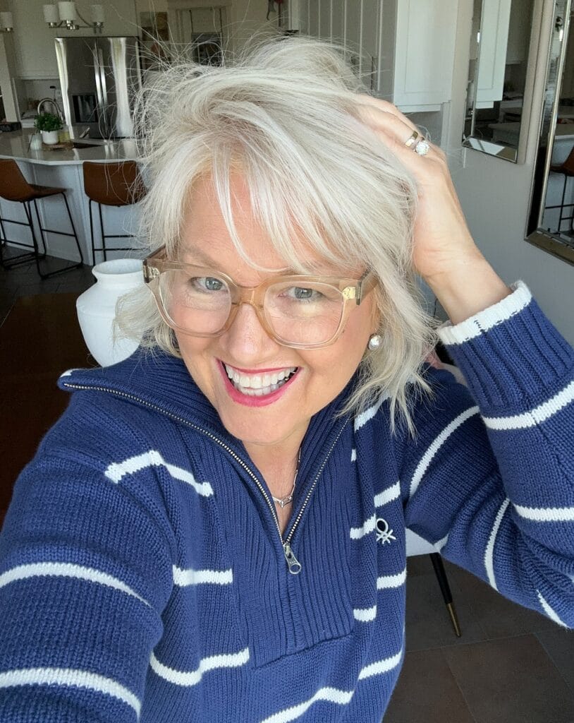 Short silver shag haircut with soft layers worn with clear glasses.