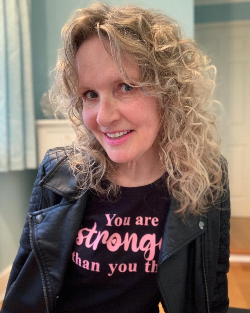 Medium length curly shag hairstyle with layered texture and soft blonde color.