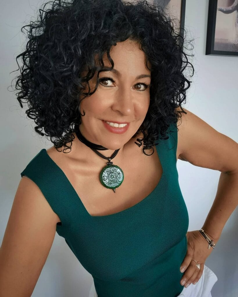 Short dark curly bob with tight defined curls and rounded shape.