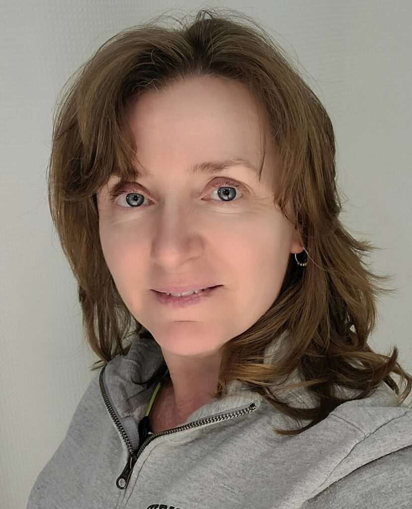 A woman with shoulder-length brunette hair featuring caramel highlights and soft wispy layers.
