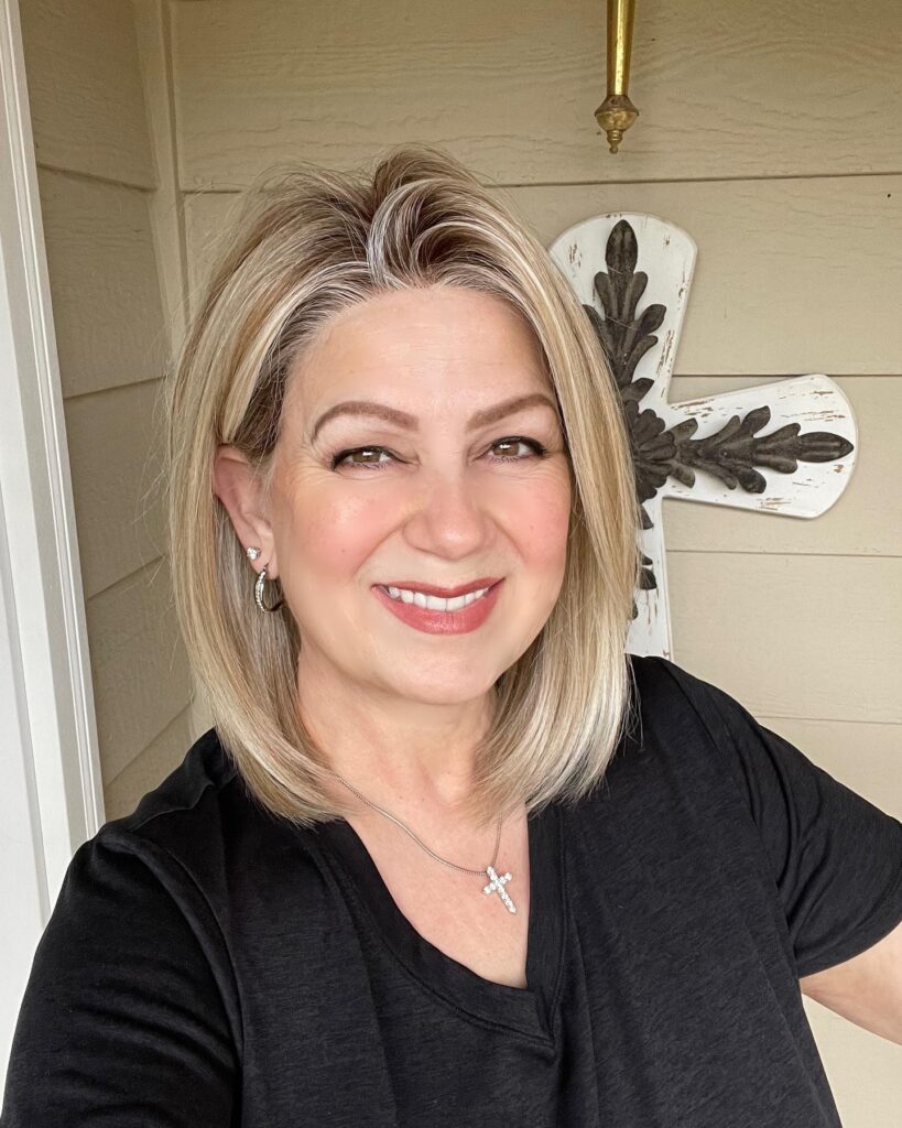 A woman with a shoulder-length sandy blonde lob featuring bright highlights and a side part.