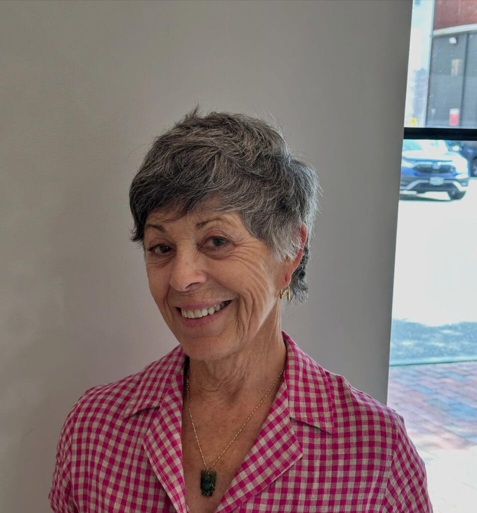 Salt and pepper layered crop haircut with soft texture and short sides.