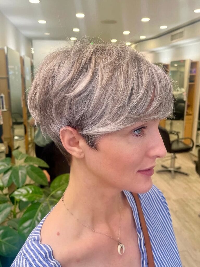 Ash blonde pixie haircut with layered crown and tapered sides.