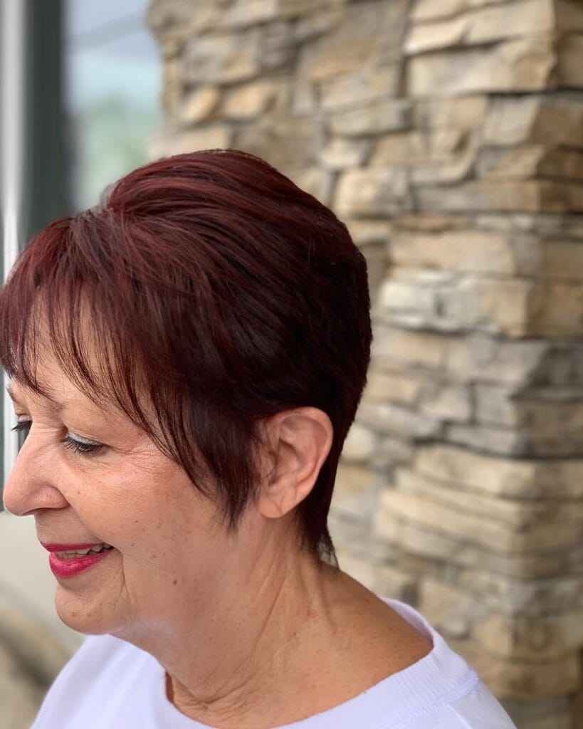 Burgundy tapered pixie haircut with short sides and softly layered crown.