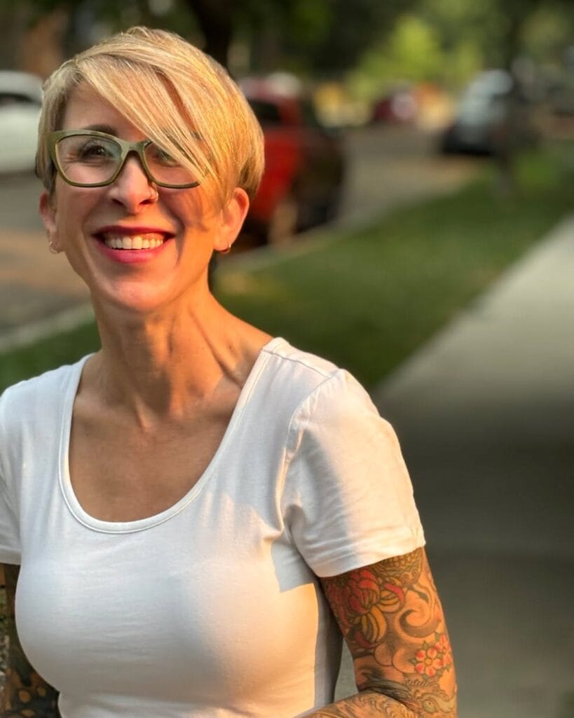 Blonde side swept pixie bob with longer fringe and short layered back.