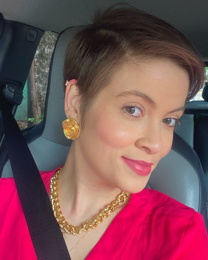 Short brunette tapered pixie haircut with smooth top and short sides.