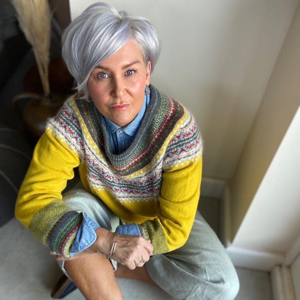 Classic silver pixie haircut with side swept fringe and short tapered sides.