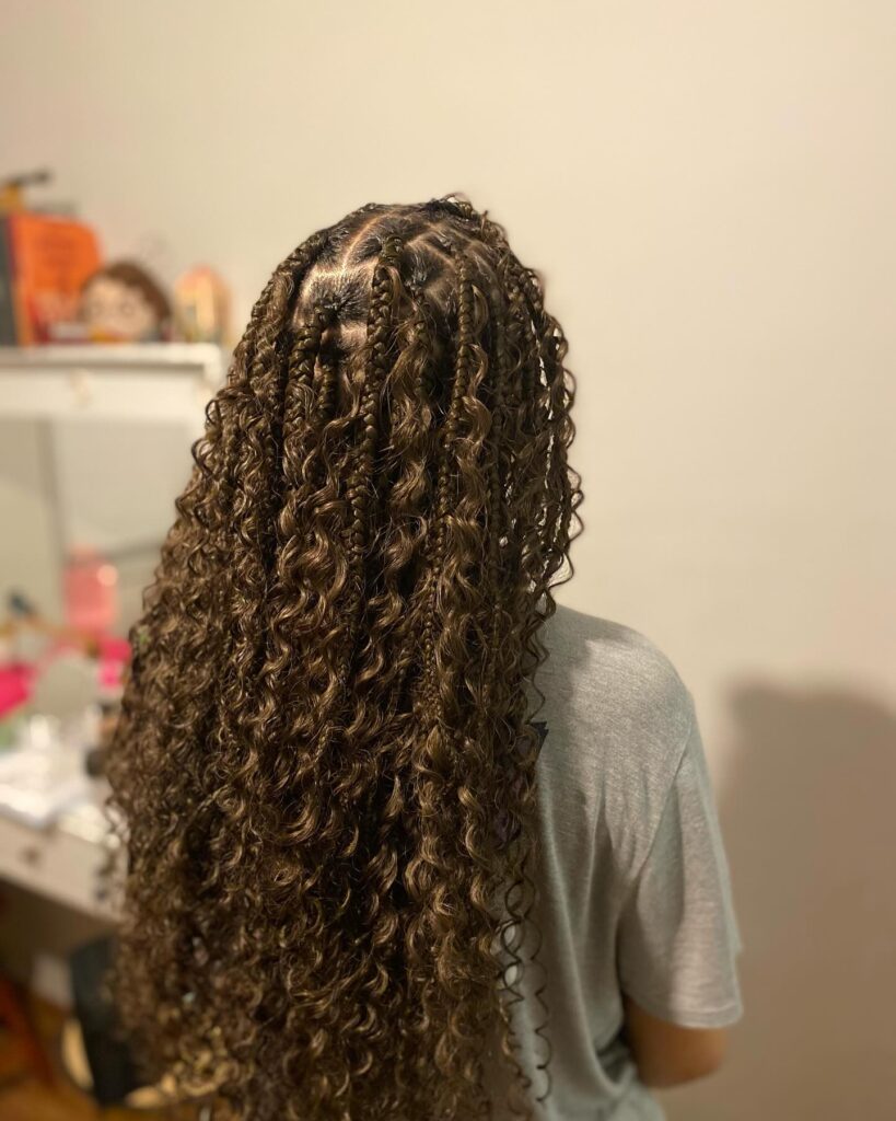 Long espresso brown goddess braids with defined curls and layered texture.