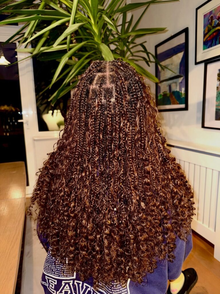 Chocolate brown goddess braids with tight curly texture and small braid sections.