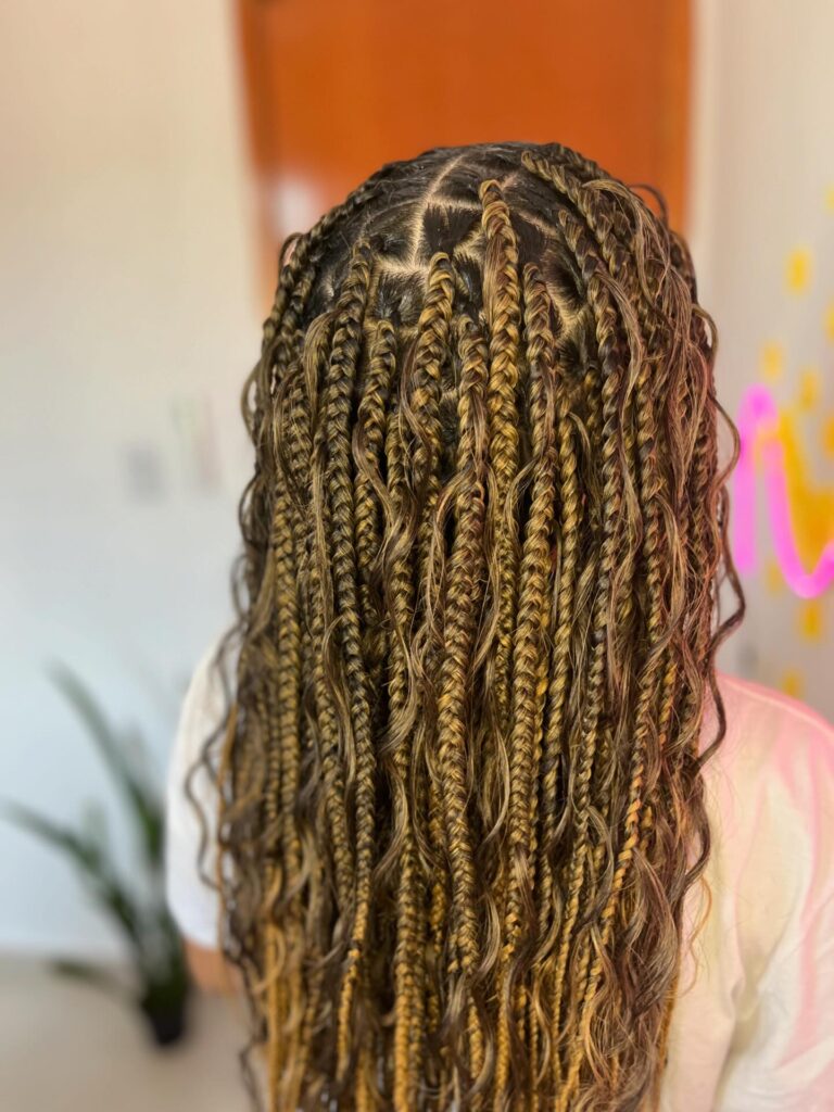 Blonde mix goddess braids with loose wavy strands and highlighted braid sections.