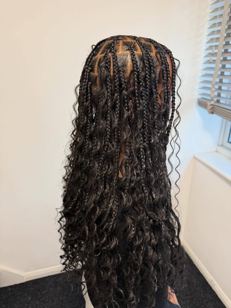 Classic black goddess braids with long curly strands and detailed braid sections.