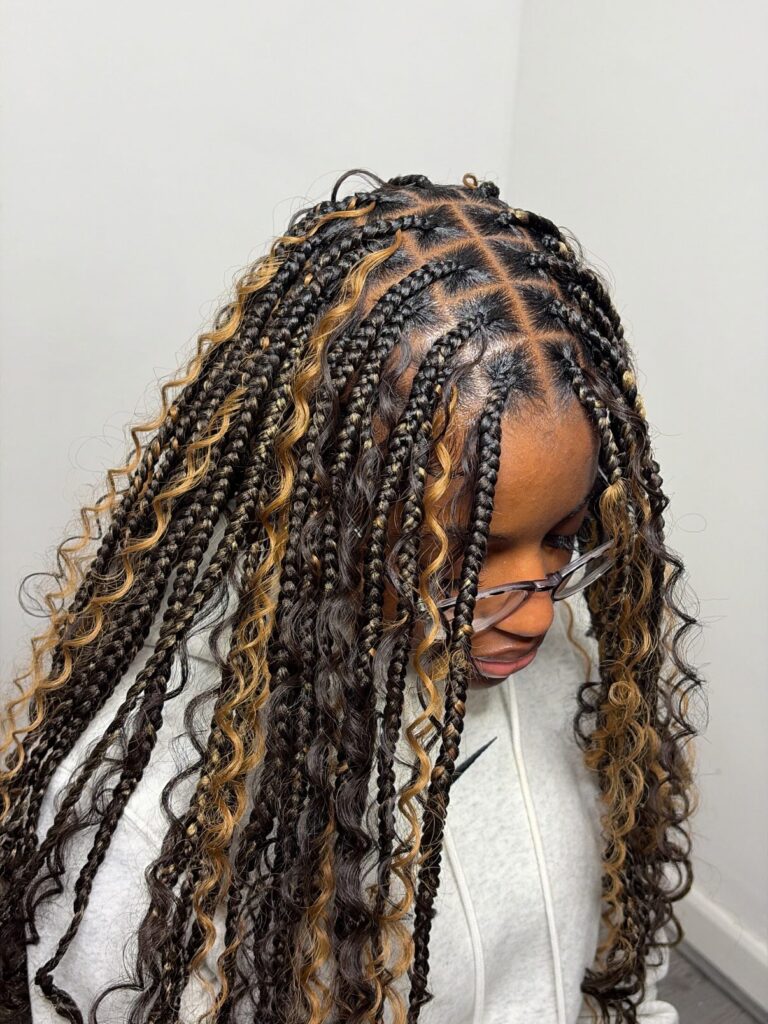 Black goddess braids with blonde highlighted curly strands and medium sized braid sections.